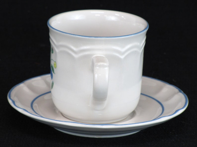May include: White ceramic teacup and saucer with a blue floral design and a blue trim.