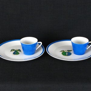Puede incluir: Dos tazas de cerámica azul y blanca con un diseño de pera en el platillo. Las tazas están sobre un fondo blanco.