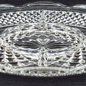 May include: A clear glass serving dish with a diamond pattern. The dish has four sections and a centre well.