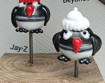 Couple de pingouins sur bloc bois, bonnet rouge et blanc