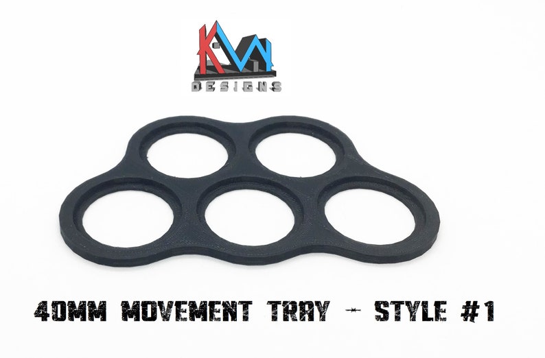 K&ouml;nnte beinhalten: Schwarzes Kunststofftablett mit f&uuml;nf runden Aussparungen, entworfen f&uuml;r die Aufnahme von 40 mm gro&szlig;en Miniaturen f&uuml;r Spiele. Das Tablett ist mit "40MM MOVEMENT TRAY - STYLE #1" beschriftet.