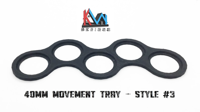 K&ouml;nnte beinhalten: Schwarzes Plastik-Bewegungs-Tablett mit f&uuml;nf runden Ausschnitten. Das Tablett ist f&uuml;r das Aufbewahren von Miniaturen f&uuml;r Tabletop-Spiele konzipiert. "40MM MOVEMENT TRAY - STYLE #3" ist auf der Unterseite des Tabletts aufgedruckt.