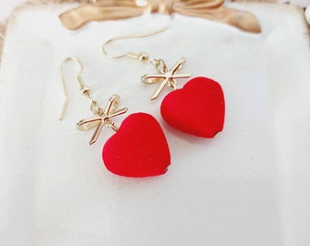 Boucles d'oreilles pendantes en alliage métalique doré. Perle coeur rouge tout doux. Bijoux fantaisie