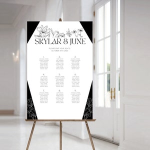 May include: Black and white wedding seating chart with floral accents. The chart lists guest names and table numbers for a wedding reception. The text reads "Skylar & June, Please find your seats, October 15th 2024."