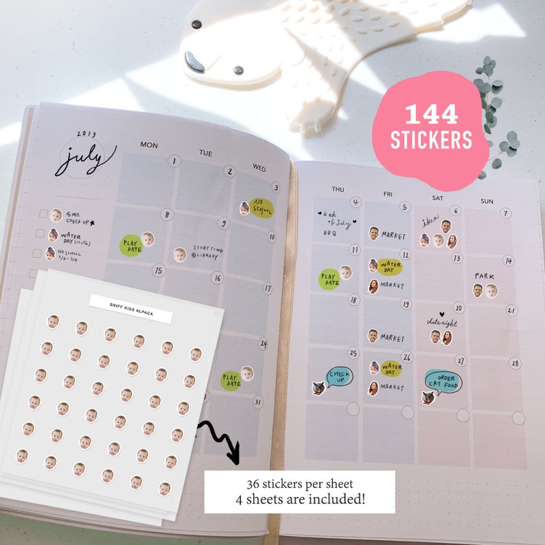 May include: A set of 144 stickers featuring a baby's face. The stickers are arranged in a grid on a white sheet of paper. The text "36 stickers per sheet" and "4 sheets are included!" is printed below the grid. The stickers are designed to be used on a calendar.