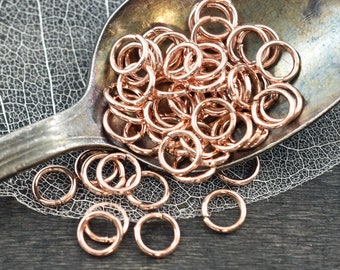 May include: A close-up of a pile of rose gold jump rings. The rings are small and delicate, and they are perfect for jewelry making.
