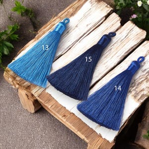May include: Three tassel trims in different shades of blue. The tassels are labeled with numbers 13, 15, and 14.