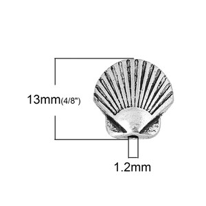 May include: A silver-colored seashell bead, 13mm (4/8") in diameter and 1.2mm thick, is displayed against a white background. The bead has a detailed, textured surface with radiating lines, resembling a real seashell. The image includes measurements.