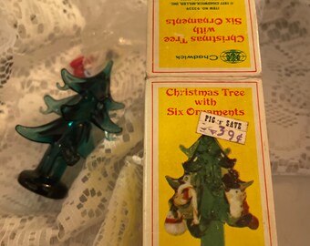 May include: A yellow box with a green Christmas tree and six ornaments. The box reads "Christmas Tree with Six Ornaments" and "PIC 'N SAVE 39¢".