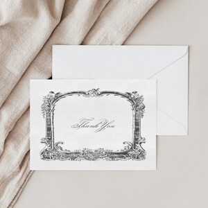 May include: A white thank you card with a black ornate frame and the text "Thank You" in cursive.