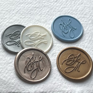 May include: Five wax seals with a monogram design. The seals are in different colors: silver, white, blue, gold, and bronze.