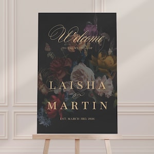 May include: A black welcome sign with gold lettering and floral accents. The sign reads "Welcome to the wedding of Laisha & Martin Est. March 3rd, 2026".