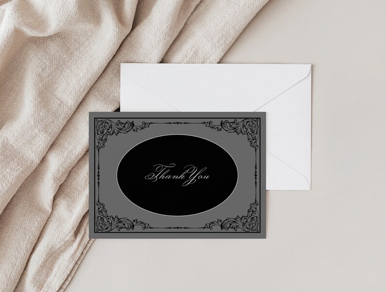 May include: A gray thank you card with a black oval in the center. The oval has a decorative black frame and the words "Thank You" written in white script.