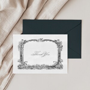 May include: A white card with a black ornate frame and the text "Thank You" inside the frame.