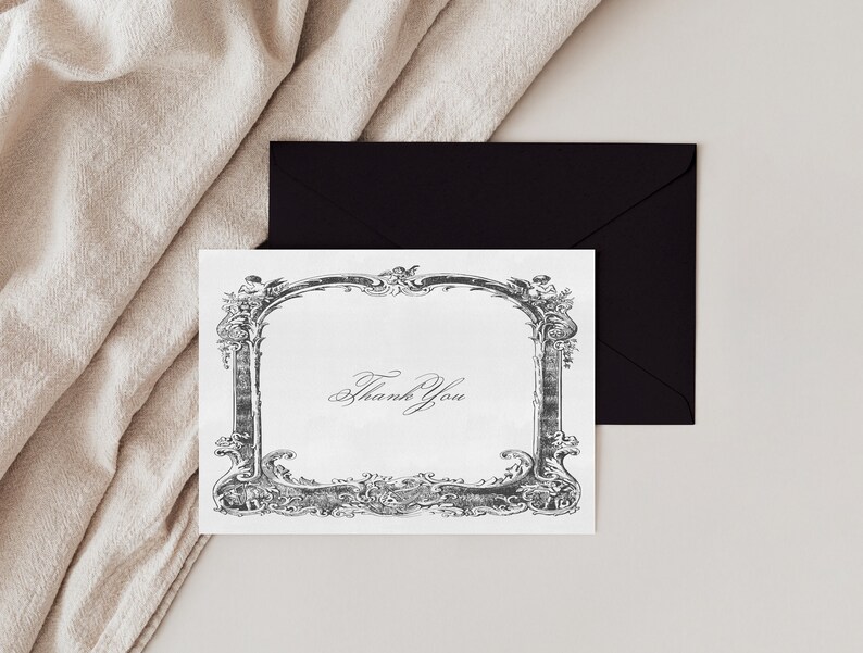 May include: A white thank you card with a black and white ornate frame. The text "Thank You" is written in cursive inside the frame.