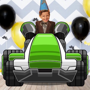 May include: A green and white toy race car with a black tire on each side. The car has a green body with white stripes and a white front bumper. The car is sitting on a wooden floor.