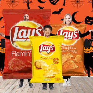 May include: Three people dressed as Lay's potato chip bags for Halloween. The bags are red, yellow, and orange, with the Lay's logo and flavor names visible. The background is orange with Halloween-themed decorations.