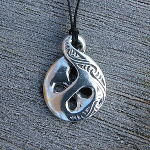 Peut inclure: Collier avec pendentif en argent en forme de nœud celtique. Le pendentif est orné de sculptures complexes et présente une finition lisse et polie.