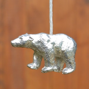 May include: A silver polar bear pull chain for a light switch. The bear is standing on all fours and has a detailed, textured surface.