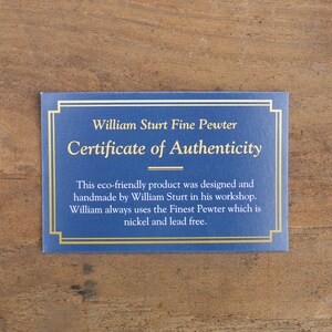 Puede incluir: Certificado azul con bordes dorados y texto. El texto dice "William Sturt Fine Pewter Certificate of Authenticity". El texto de abajo indica que el producto es ecol&oacute;gico, hecho a mano y sin n&iacute;quel ni plomo.