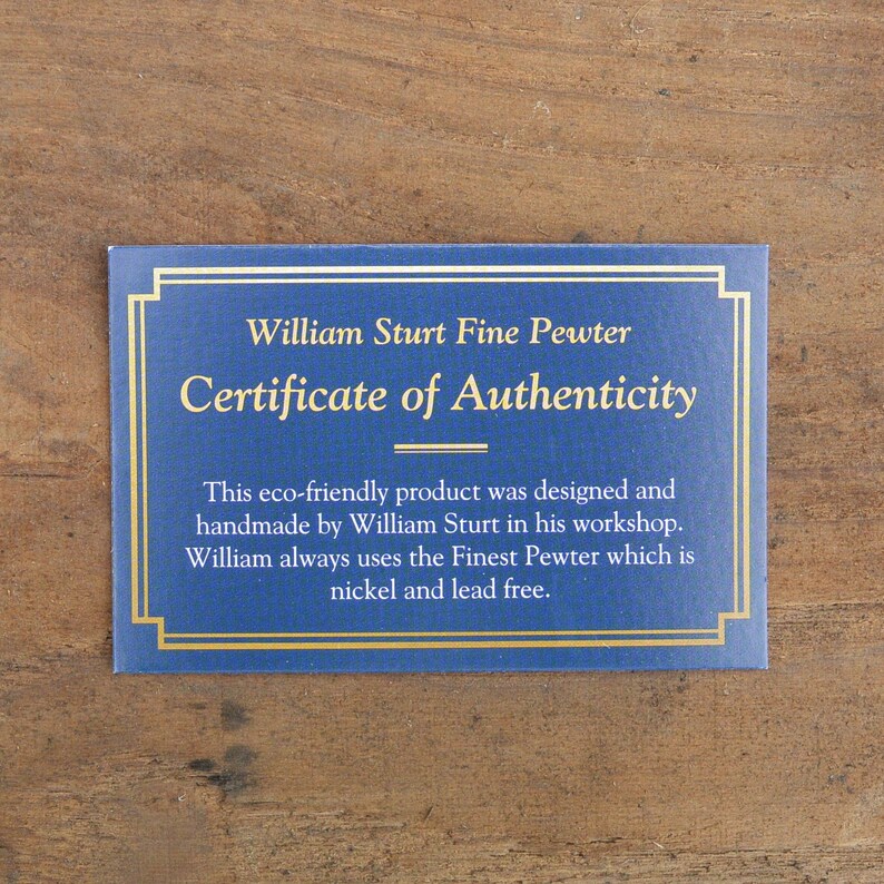 Puede incluir: Certificado azul con bordes dorados y texto. El texto dice "William Sturt Fine Pewter Certificate of Authenticity". El texto de abajo indica que el producto es ecol&oacute;gico, hecho a mano y sin n&iacute;quel ni plomo.