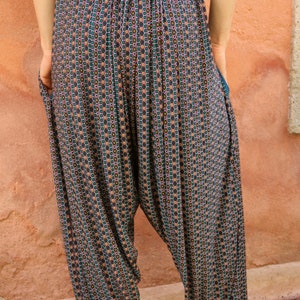 May include: A pair of loose-fitting pants with a geometric pattern in shades of green, brown, and white. The pants have a wide leg and a drawstring waist.