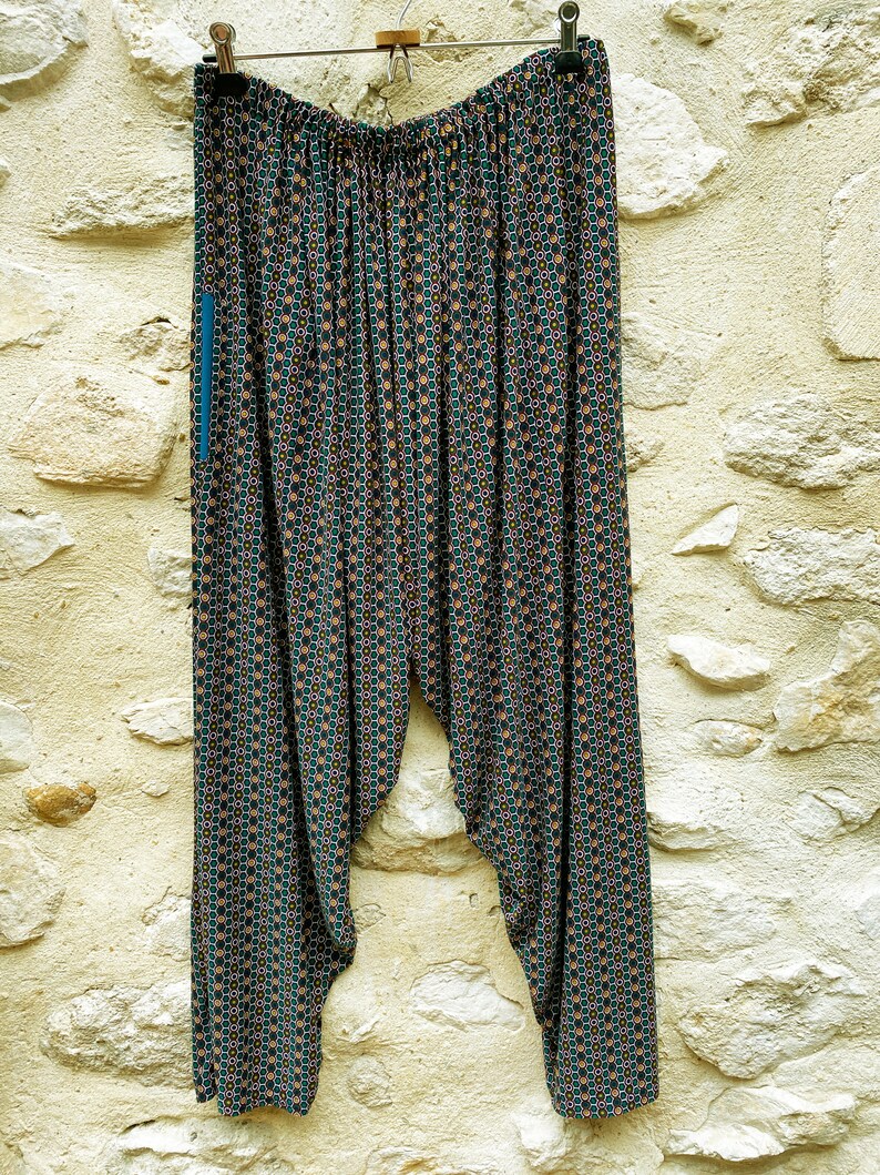 May include: Black and green patterned pants with a geometric design. The pants have a wide leg and a loose fit.