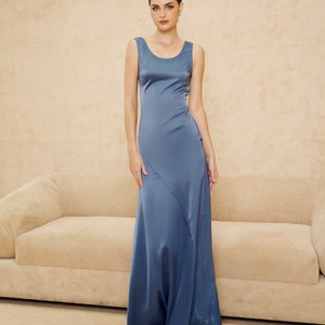 May include: A long, sleeveless, blue satin dress with a scoop neckline. The dress has a fitted bodice and a flowing skirt.