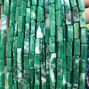Puede incluir: Una hebra de cuentas rectangulares de piedra preciosa verde y blanca. Las cuentas son lisas y pulidas, con un patrón natural de mármol.