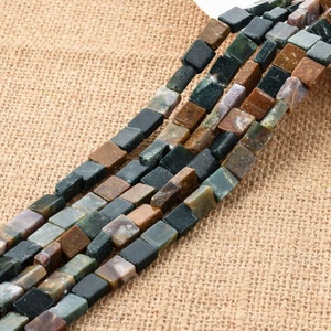 Puede incluir: Una hebra de cuentas cuadradas de piedra preciosa de color verde, marrón y negro. Las cuentas están hechas de piedra natural y tienen un acabado pulido.