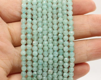 May include: A strand of light blue faceted gemstone beads. The beads are small and round, and they are strung on a clear thread.