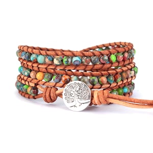 May include: Multi-strand leather wrap bracelet with colorful beads and a silver tree of life charm.