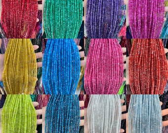 May include: Assortment of faceted gemstone beads in various colours, including red, green, purple, pink, yellow, light green, blue, white, and grey. The beads are strung on a string and are approximately 2 mm in diameter.