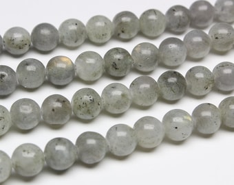 May include: A strand of round, grey gemstone beads with a slight iridescent sheen. The beads are strung on a clear thread and are approximately 8mm in diameter.