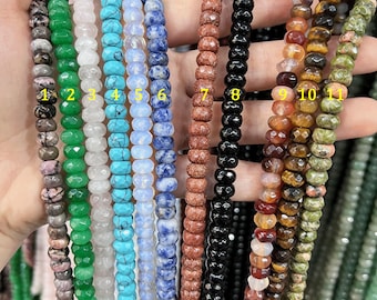 May include: Eleven strands of gemstone beads, each with a different color and pattern. The beads are faceted and have a polished finish. The strands are numbered 1 through 11.