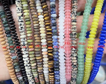 May include: Assortment of 15 strands of colorful gemstone beads. Each strand is approximately 16 inches long and features a different type of stone, including green, black, brown, white, pink, blue, and yellow.
