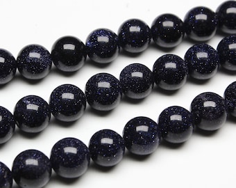 May include: A strand of dark blue gemstone beads with a speckled texture. The beads are round and uniform in size.