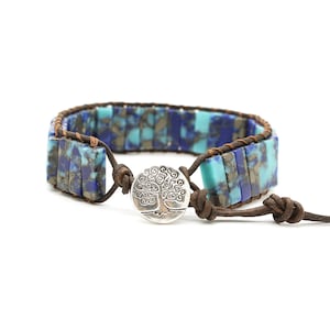 May include: A brown leather wrap bracelet with blue and turquoise gemstone beads and a silver tree of life charm.