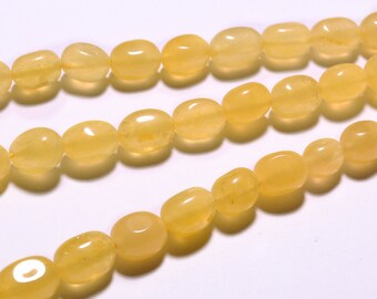 May include: A strand of yellow oval-shaped beads. The beads are smooth and polished, and they have a slightly translucent appearance.