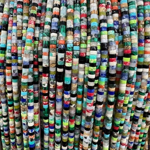 Peut inclure: Gros plan sur une variété de perles de pierres précieuses colorées. Les perles sont rondes et ont une finition lisse et polie. Elles sont enfilées sur une ficelle et sont prêtes à être utilisées pour la fabrication de bijoux.