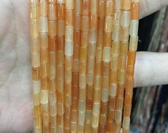 May include: A strand of orange and yellow gemstone beads, each bead is a rectangular prism shape.