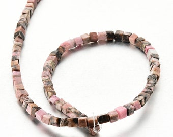 Peut inclure: Un brin de perles carrées de couleur rose et marron en pierre naturelle. Les perles sont enfilées sur un cordon élastique transparent.