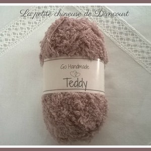 Puede incluir: Un ovillo de hilo suave y esponjoso de color rosa, etiquetado como "Go Handmade Teddy".