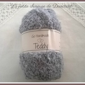 Puede incluir: Un ovillo de hilo gris con la etiqueta "Go Handmade Teddy".