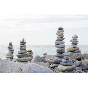 Peut inclure: Une collection de pierres grises empilées en formation équilibrée sur une plage. Les pierres sont disposées à différentes hauteurs et tailles, créant une scène visuellement attrayante et apaisante.