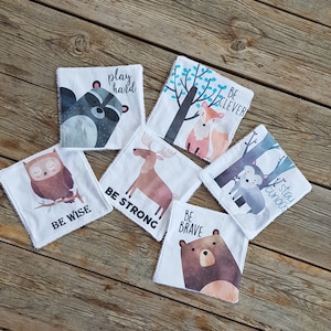 May include: Set of 7 white fabric squares with colorful animal illustrations and inspirational messages. The messages include "Play Hard", "Be Clever", "Stay Curious", "Be Wise", "Be Strong", "Be Brave".