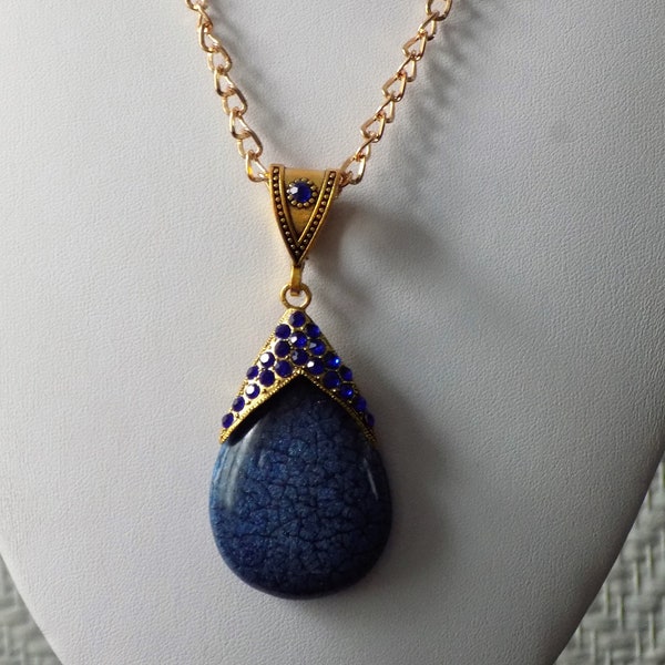 Collier mi-long,coloris or et bleu,grand pendentif goutte,strass et perle cristal.