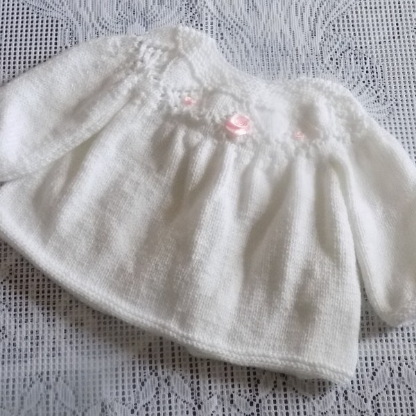 Robe manches longues pour bébé réalisée main au tricot , coloris blanc , fleurs en satin roses , taille 3/6 mois.