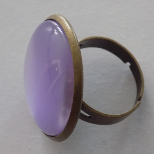 Grande bague ajustable ronde bronze , cabochon en résine de coloris mauve.