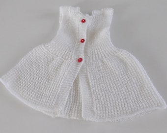 Robe pour bébé tricotée main , coloris blanc , boutons rouges forme fleur , taille 6 à 9 mois.